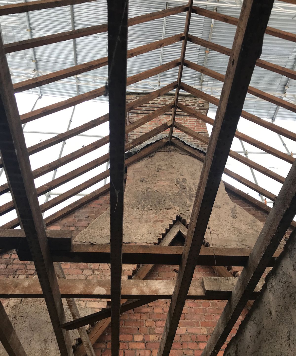 Shot pointing upwards at a roof with the beams but otherwise completely open
