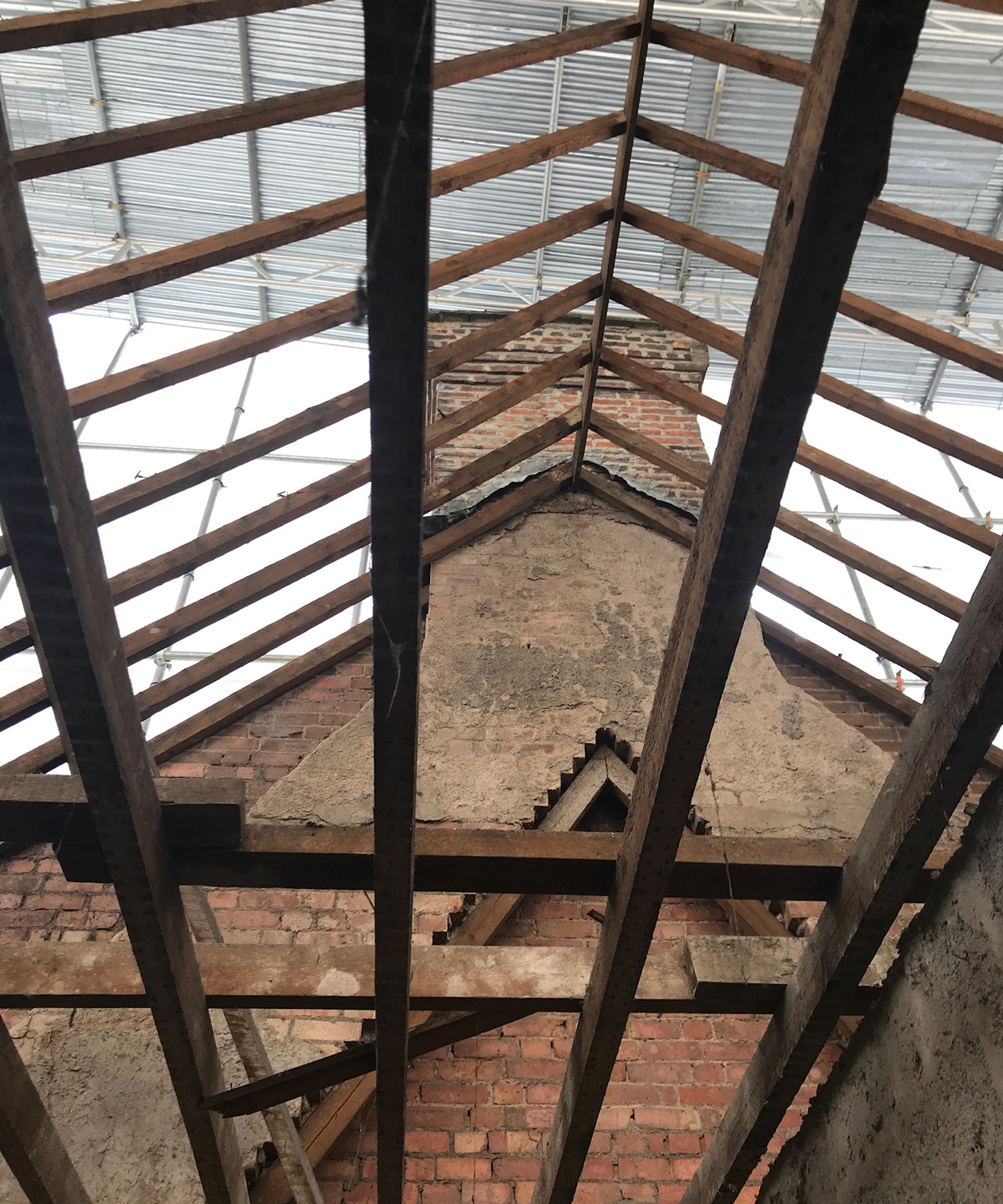 Shot pointing upwards at a roof with the beams but otherwise completely open