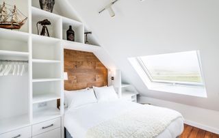 bed in a converted chapel with storage built around it