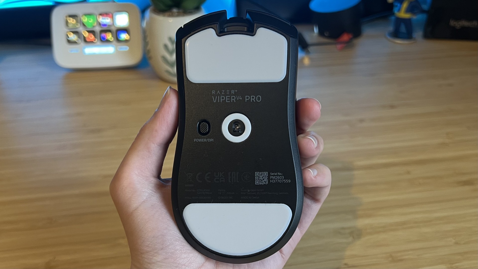 Razer Viper V4 Pro being held upside down with the sensor and DPI button visible