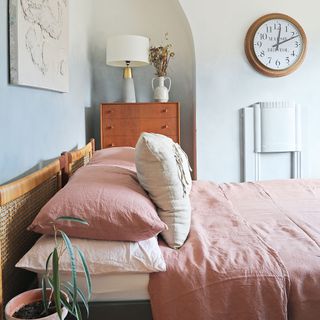 Bedroom with pink bedlinen and ombre paint effect on walls