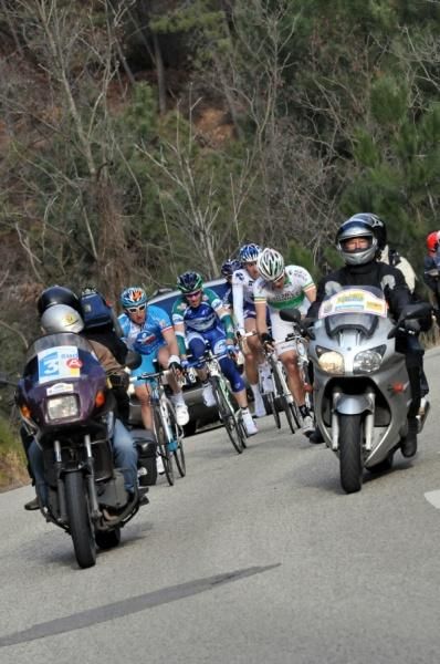 The breakaway are surrounded by vehicles as they climb together