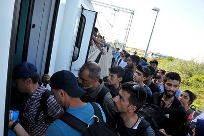 Migrants try to get on a train in Croatia.