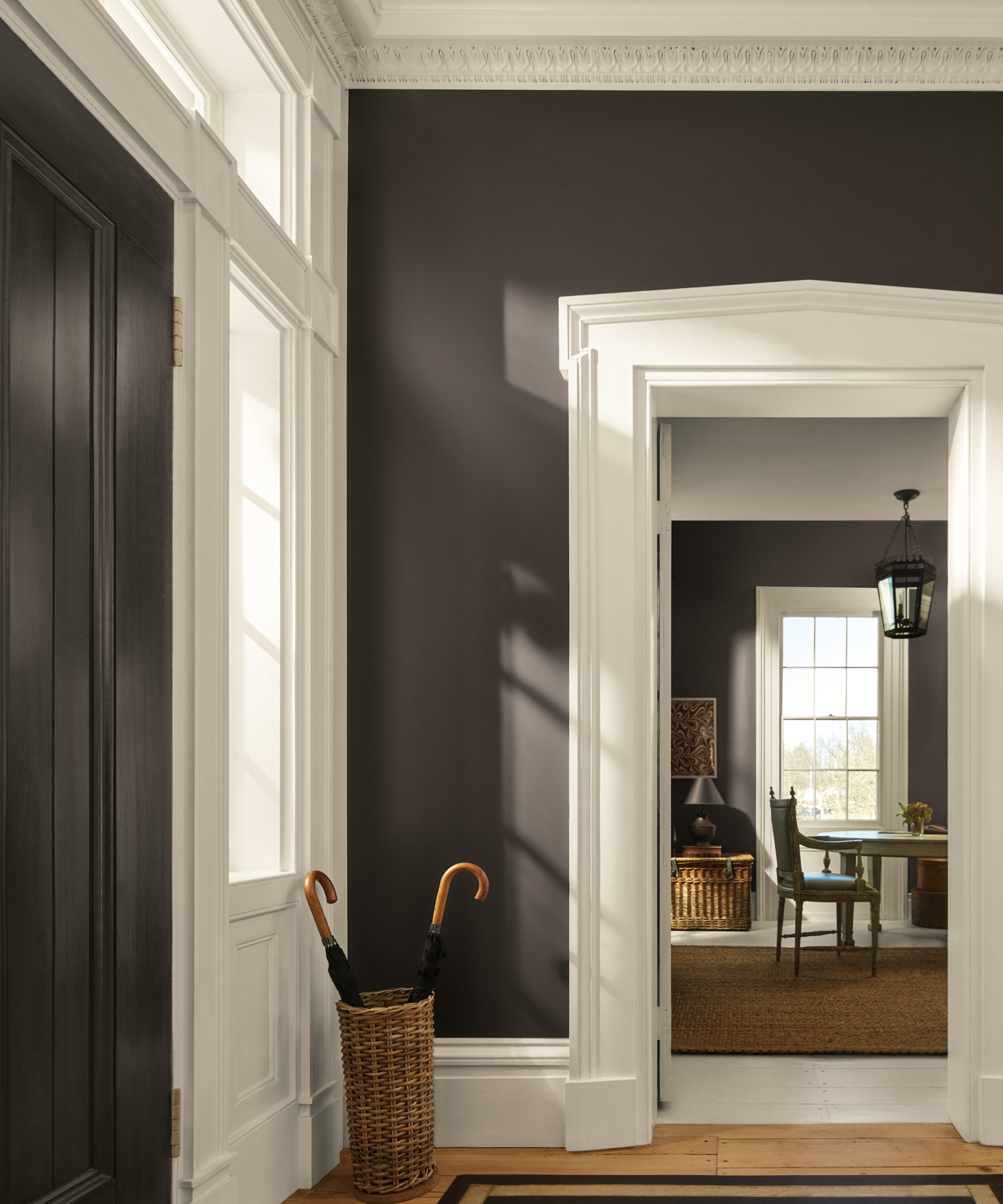 an entryway with walls painted in Benjamin Moore&#039;s 2026 color of the year, a shade of charcoal gray with subtle notes of espresso titled Silhouette