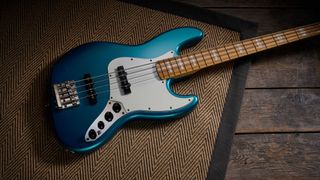 Squier Classic Vibe 70s Jazz Bass Active: finished in Ocean Turquoise, this keenly priced four-string is photographed in close-up with a patterned rug and wooden floor in the background.