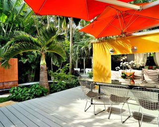 A residential backyard with outdoor room, deck, and deck shade