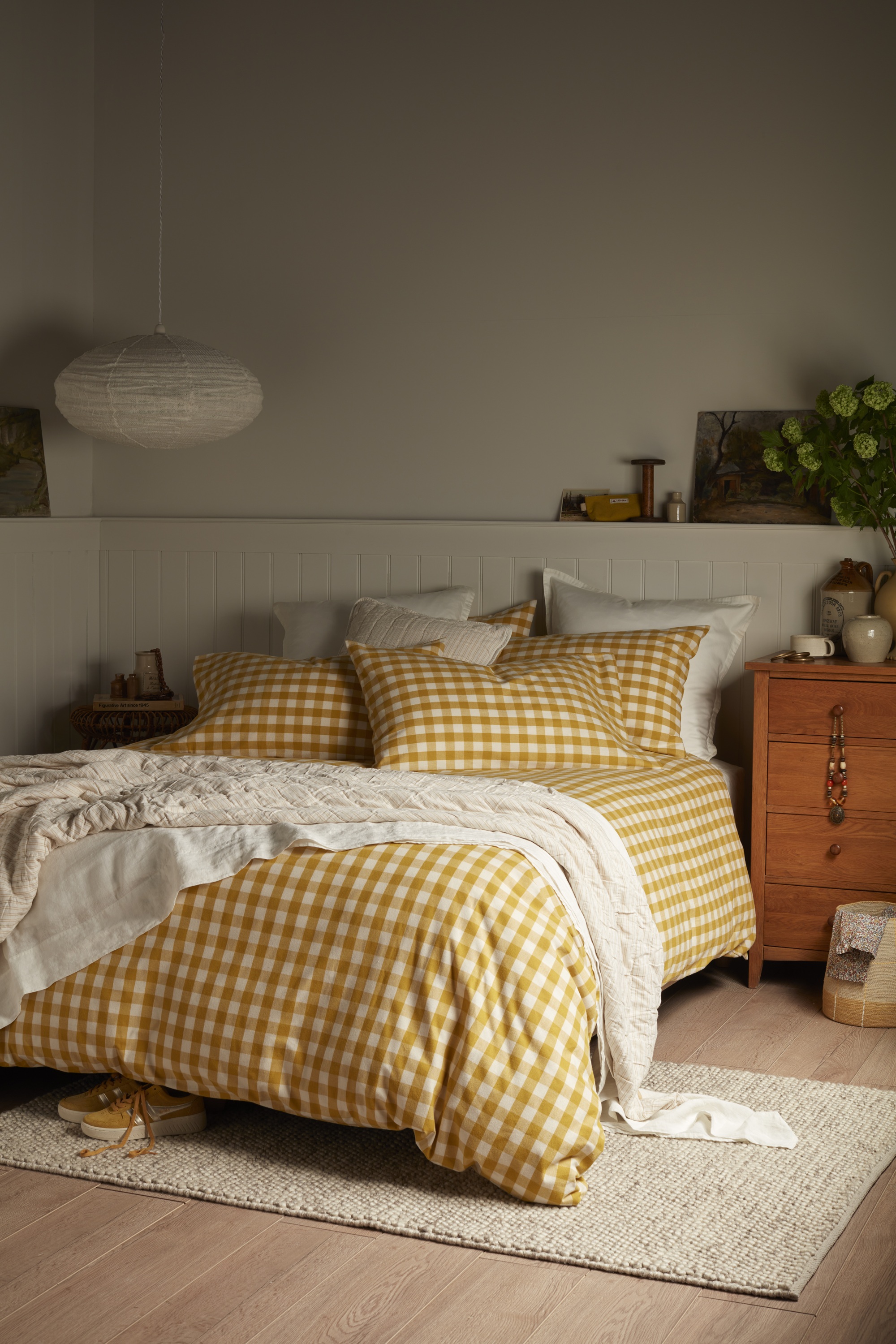 yellow gingham bedding on a bed in a neutral room