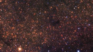 deep-space photo showing thousands of reddish-orange dots, each of which is a distant star