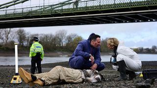 Nikki and Jack crouch over a body by Hammersmith Bridge in Silent Witness season 27