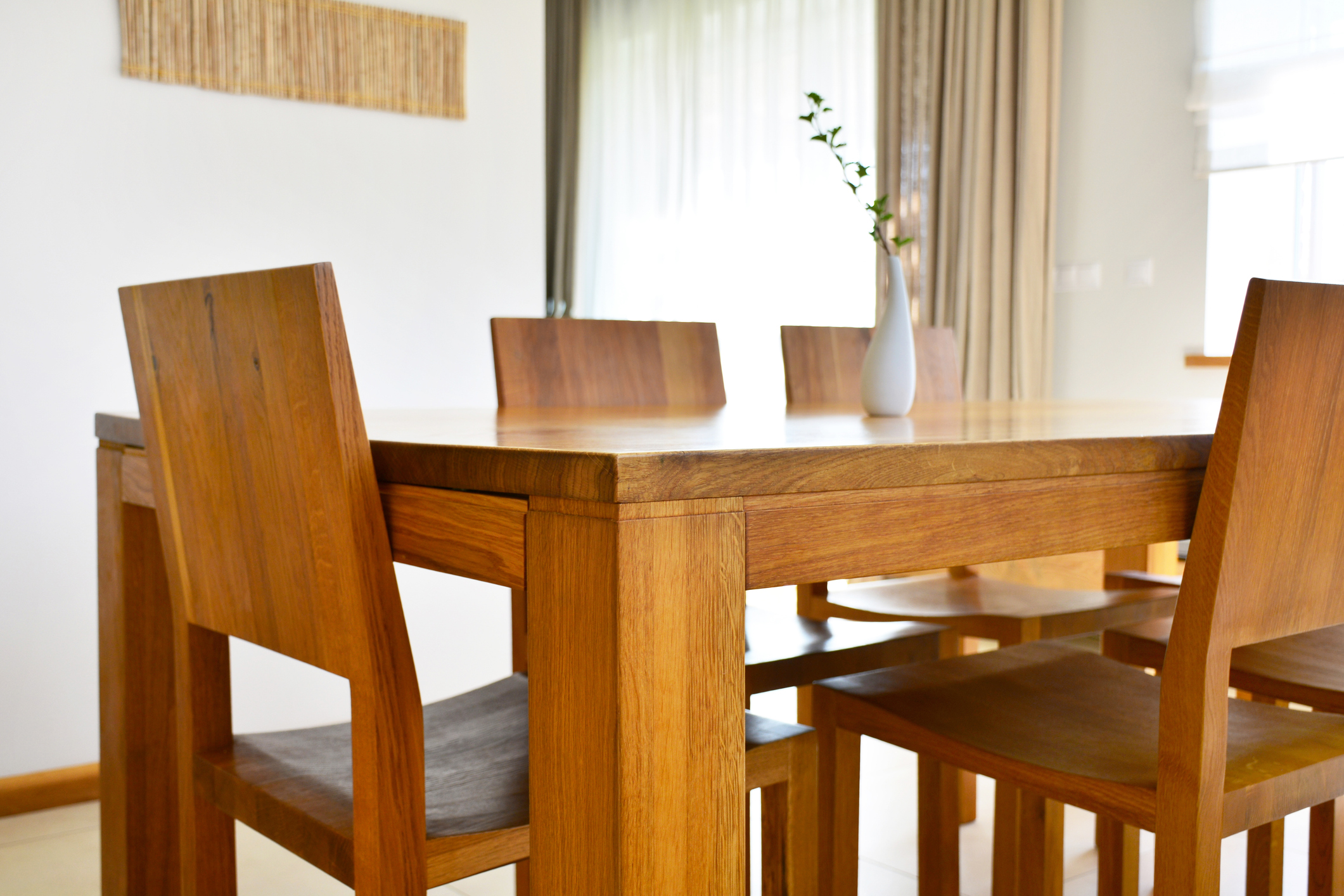 Natural oak wood dining table and chairs in neutral modern interior design house