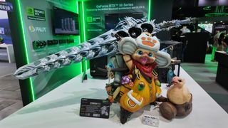 A 3D printed custom PC case build fashioned to look like a triumphantly-posed Palico from Capcom's Monster Hunter series. It has a long sword strapped to its backpack. A GPU features prominently in the sword's hilt. This was photographed on the show floor at Computex 2025.