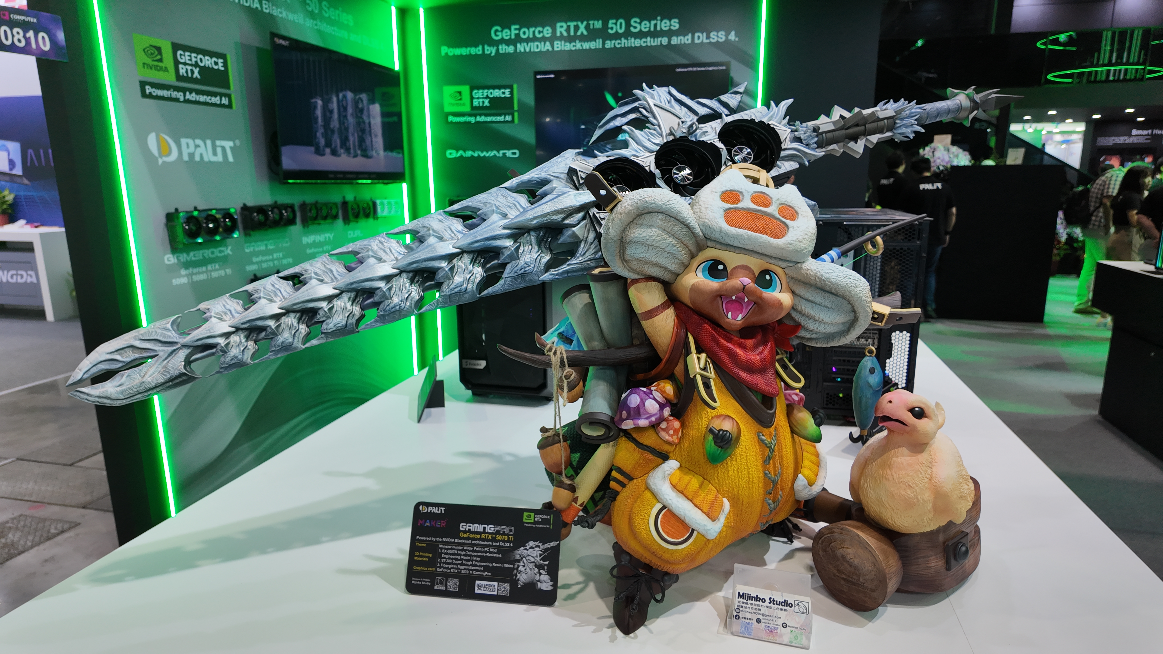 A 3D printed custom PC case build fashioned to look like a triumphantly-posed Palico from Capcom&#039;s Monster Hunter series. It has a long sword strapped to its backpack. A GPU features prominently in the sword&#039;s hilt. This was photographed on the show floor at Computex 2025.