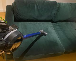 VAX Blade 5 Dual Pet & Car Cordless Vacuum Cleaner being used with power attachment on velvet sofa
