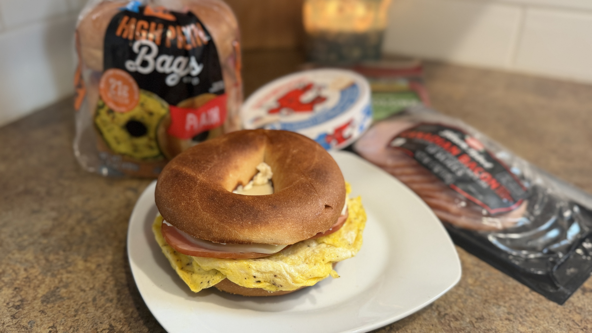 Bagel on a plate with packets of ingredients in background