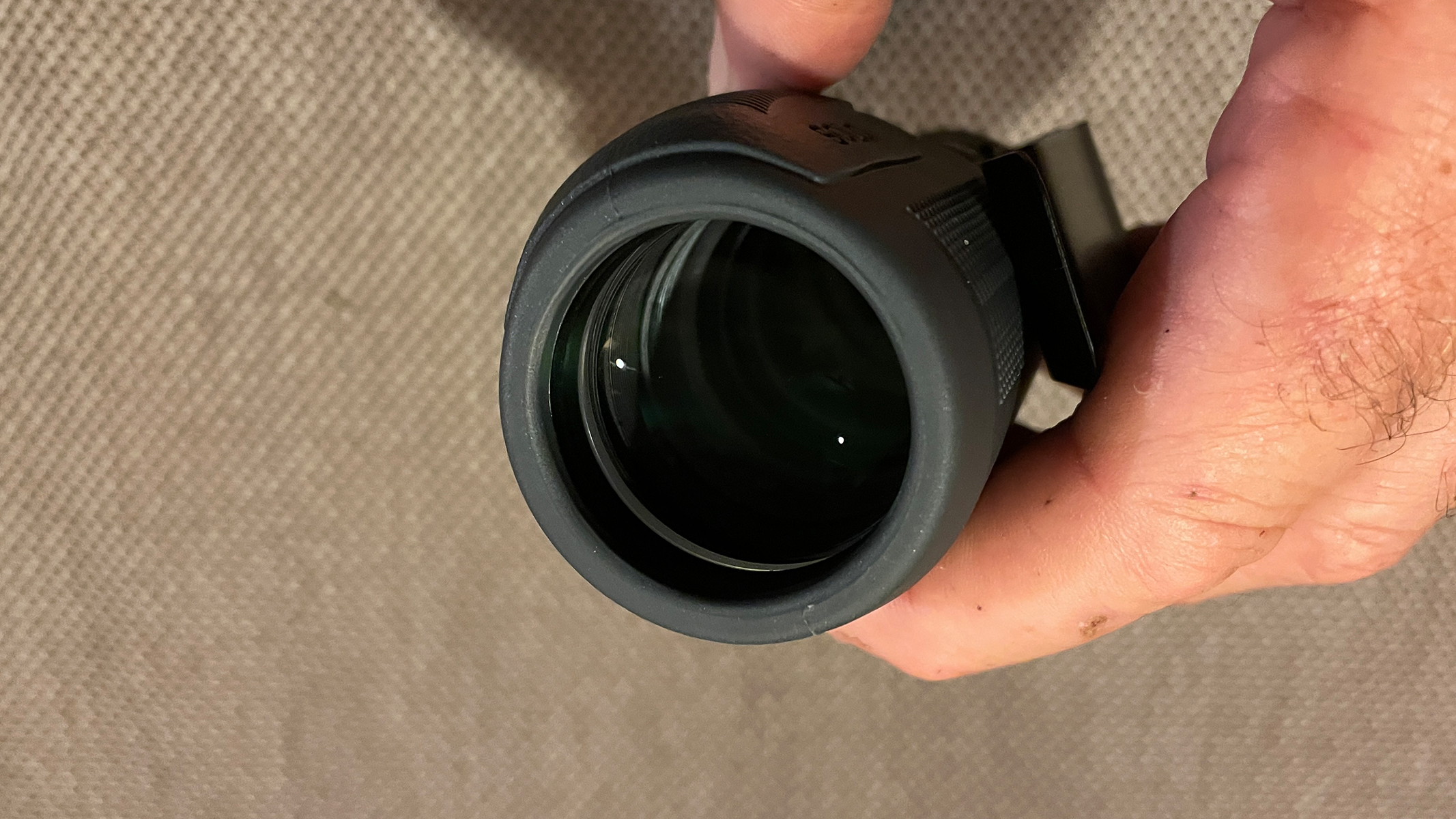 A close up of the objective lens on a monocular