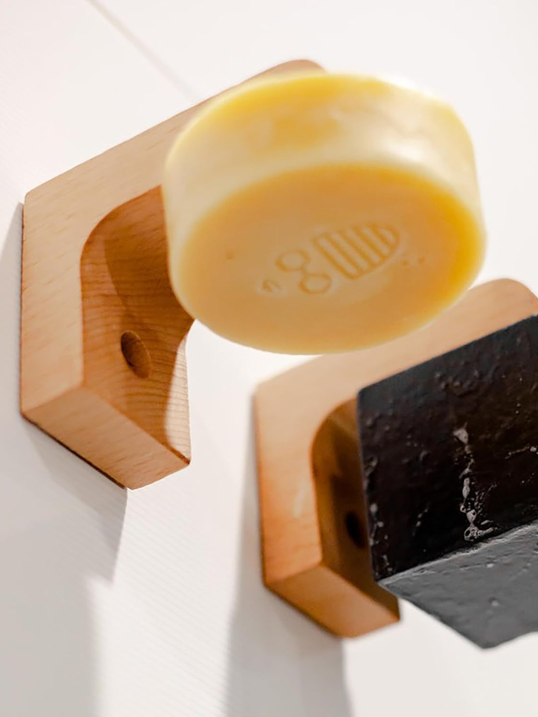 A pair of wood soap holders with a magnetic back
