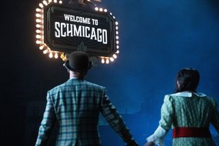 (L to R) Keegan-Michael Key and Cecily Strong in front of a "Welcome to Schmicago" sign in "Schmigadoon!," premiering April 7, 2023 on Apple TV+.