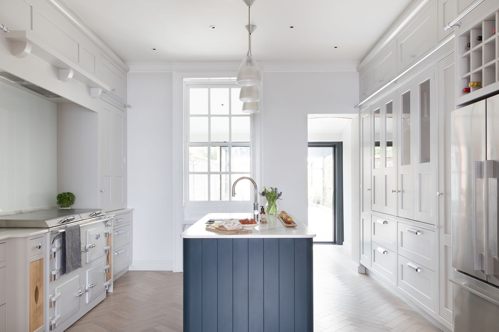 blue paneled island in white kitchen