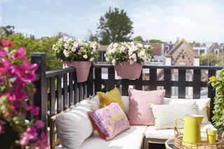 Balcony with corner couch and railings with planters