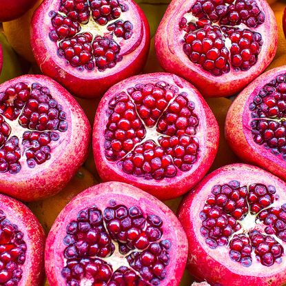 ripe red pomegrante fruits sliced and splashed in water