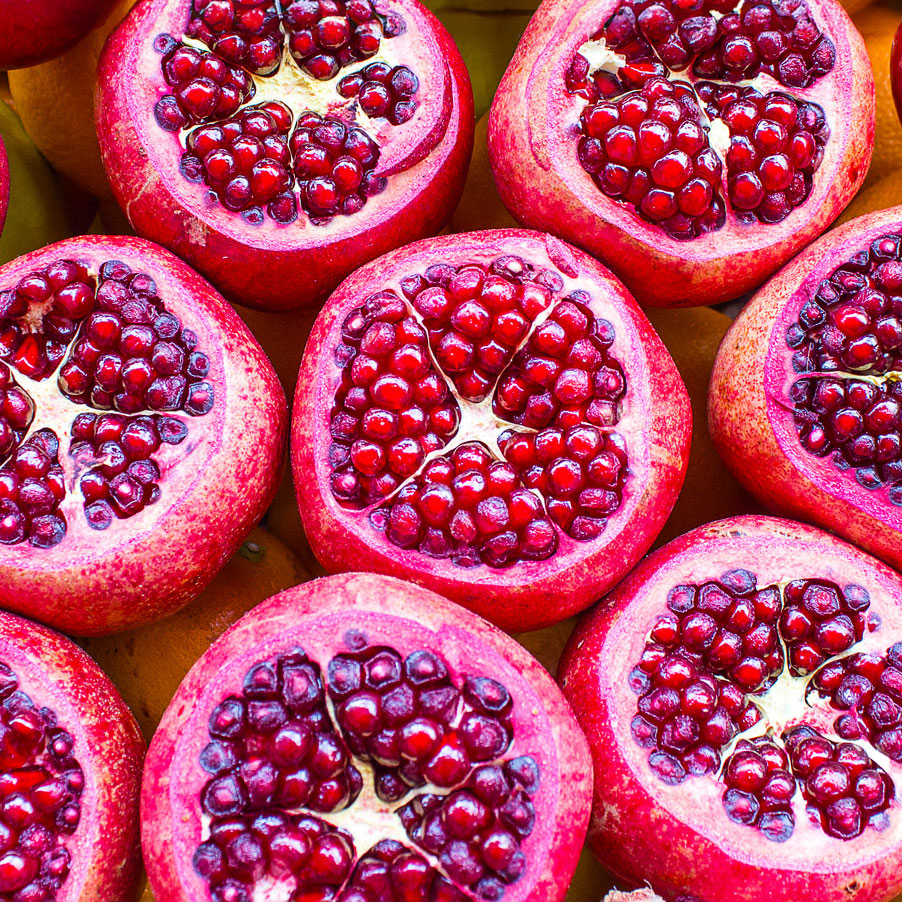 ripe red pomegrante fruits sliced and splashed in water