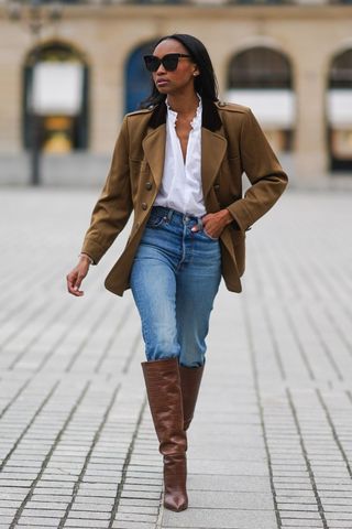 a woman wearing denim jeans and brown boots