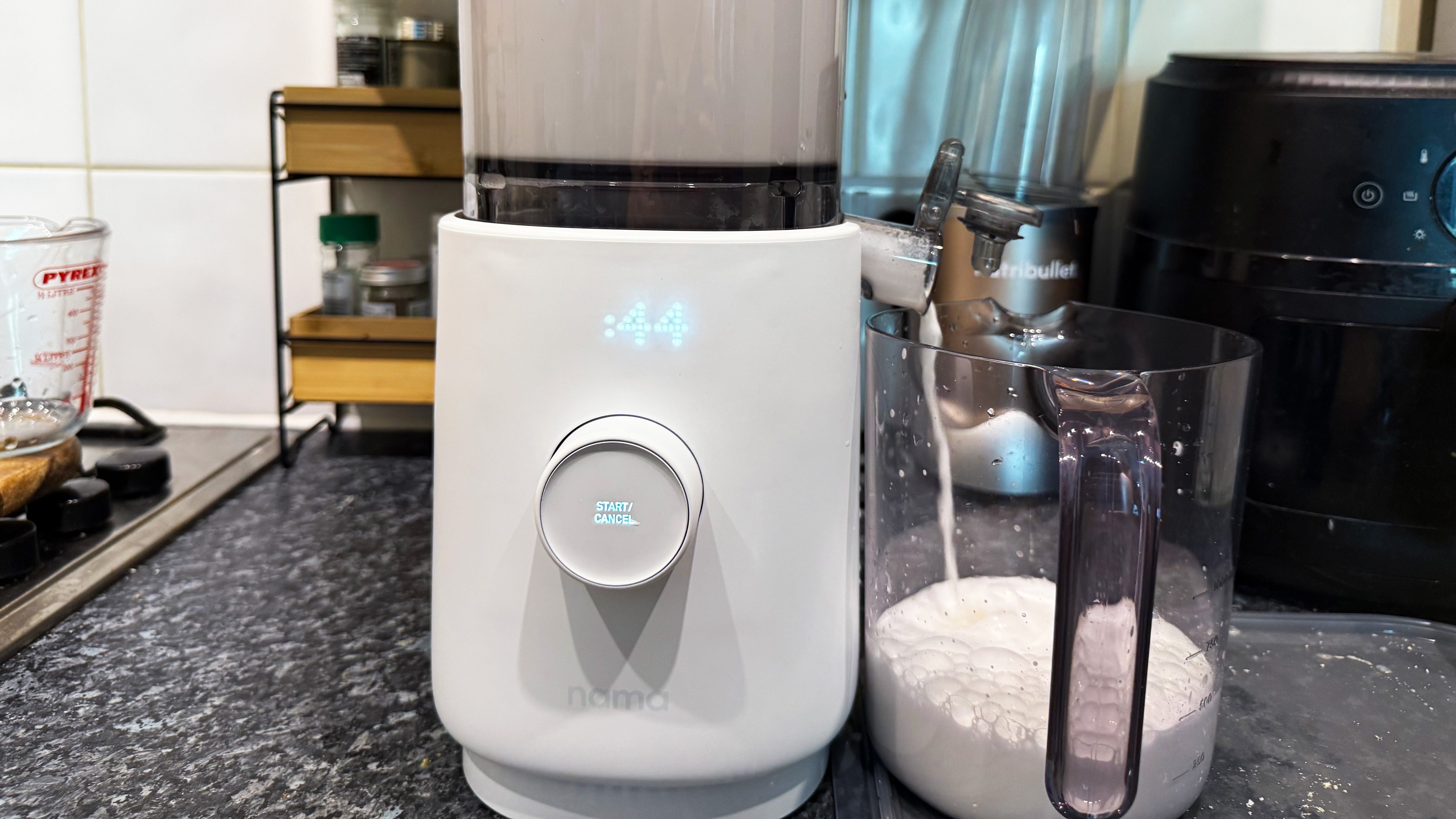 the nama m1 milk maker in action showing the straining feature