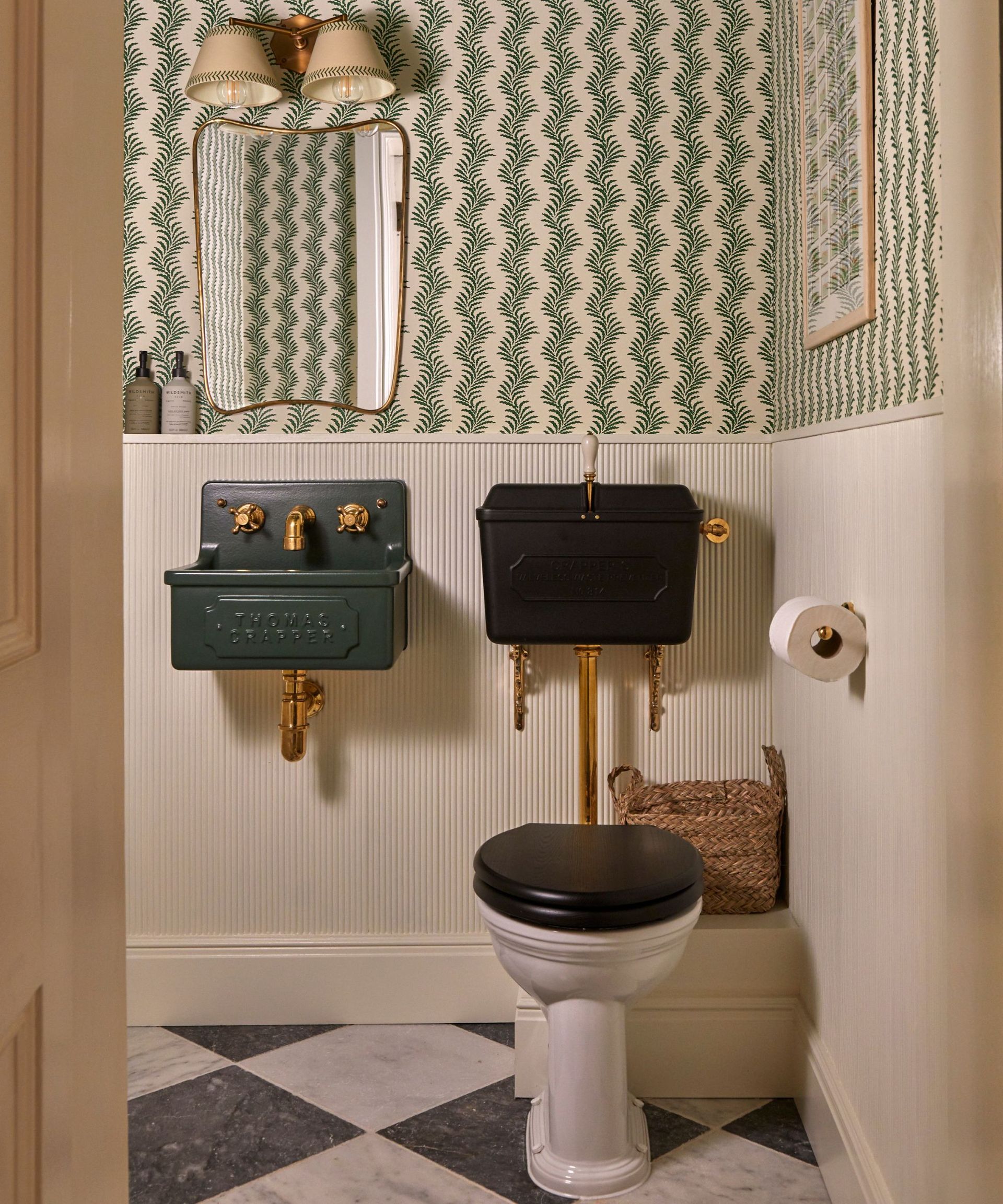 A vintage style bathroom with Thomas Crapper sanitaryware and a traditional botanical stripe wallpaper