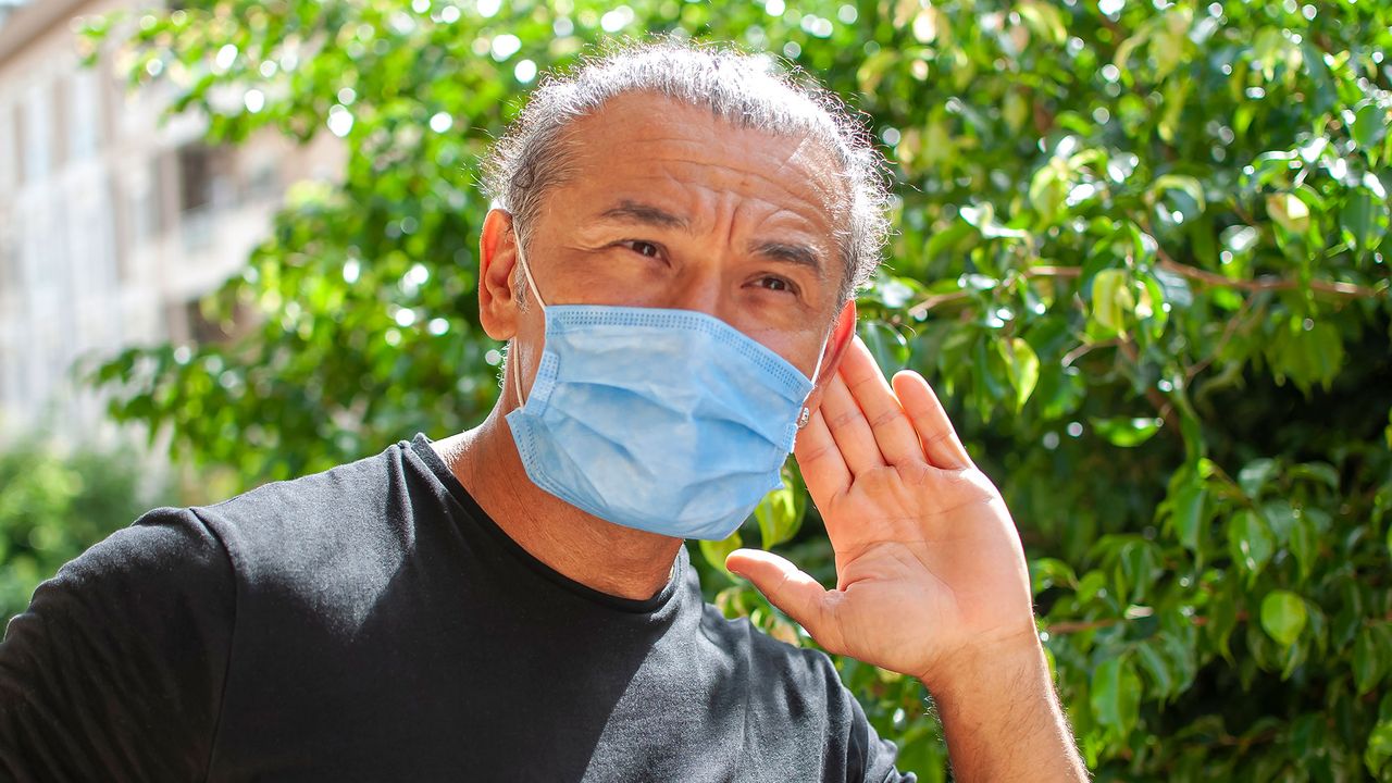 Man struggling to hear whilst wearing a mask during the Covid-19 pandemic