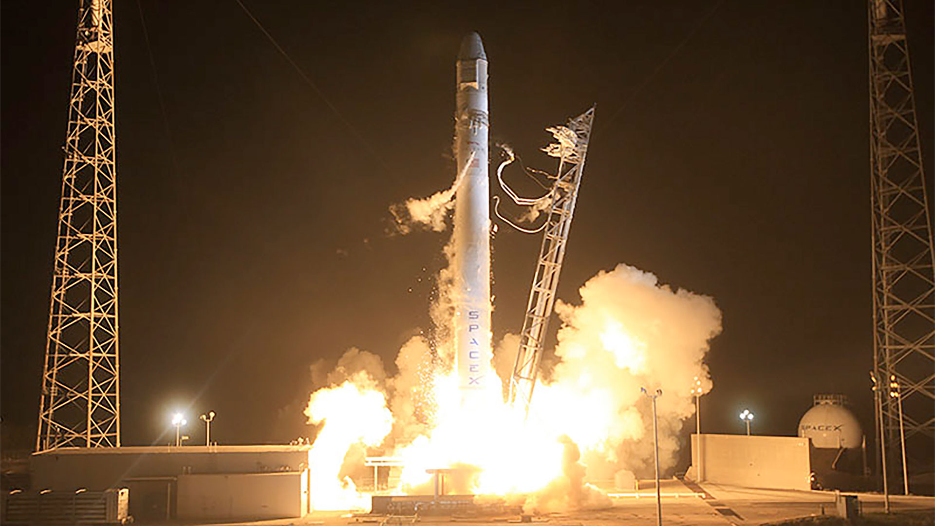 a white rocket lifts off into a night sky