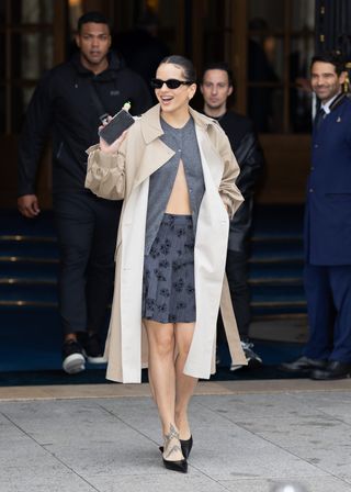 Rosalia at Paris Fashion Week wearing a gray sweater and a gray patterned skirt