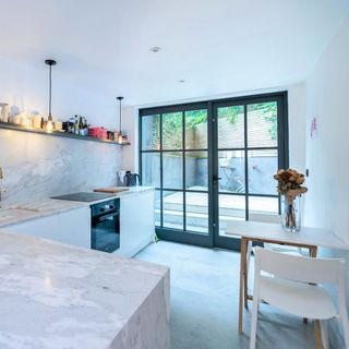 kitchen with white wall white counter bifold door and shelf
