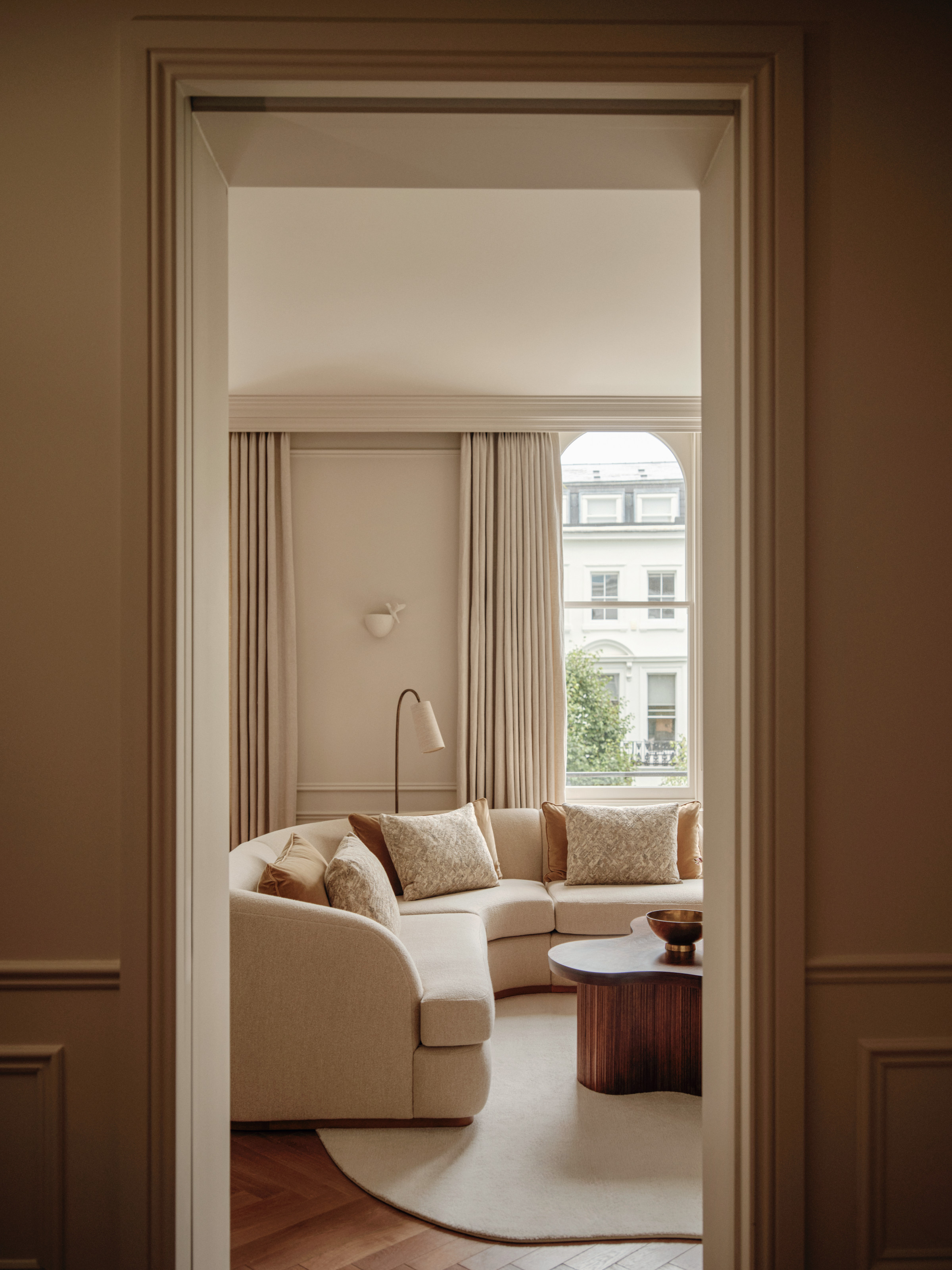 Warm white living room with curved sofa and curved floor lamp