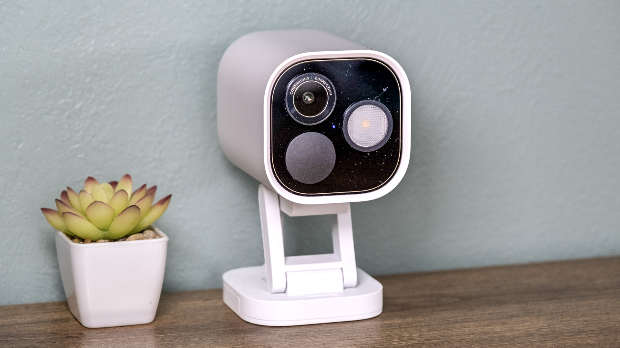 Aqara Camera Hub G5 Pro on a shelf with a small cactus.
