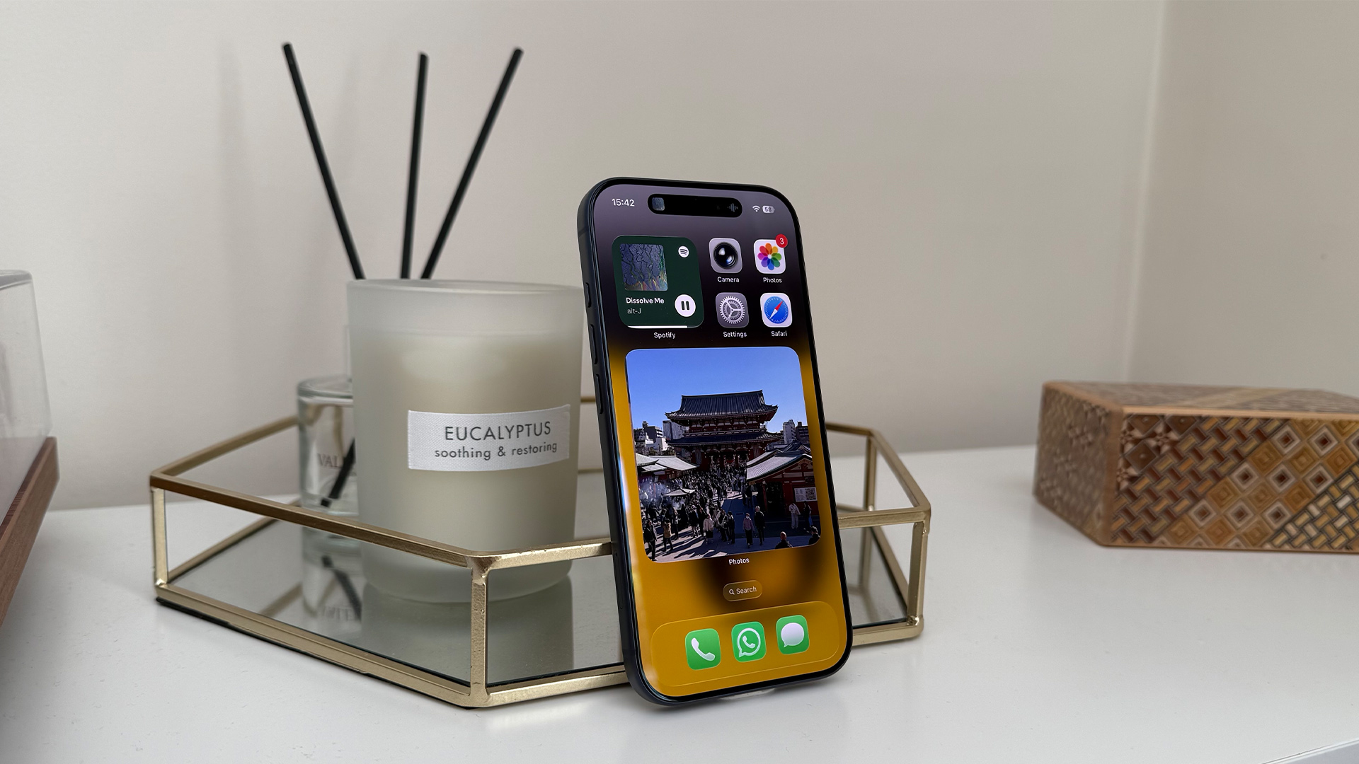 Apple iPhone 17 Pro smartphone leaning upright next to candle