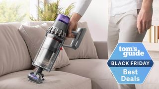 A Dyson cordless vacuum in handheld mode on a couch