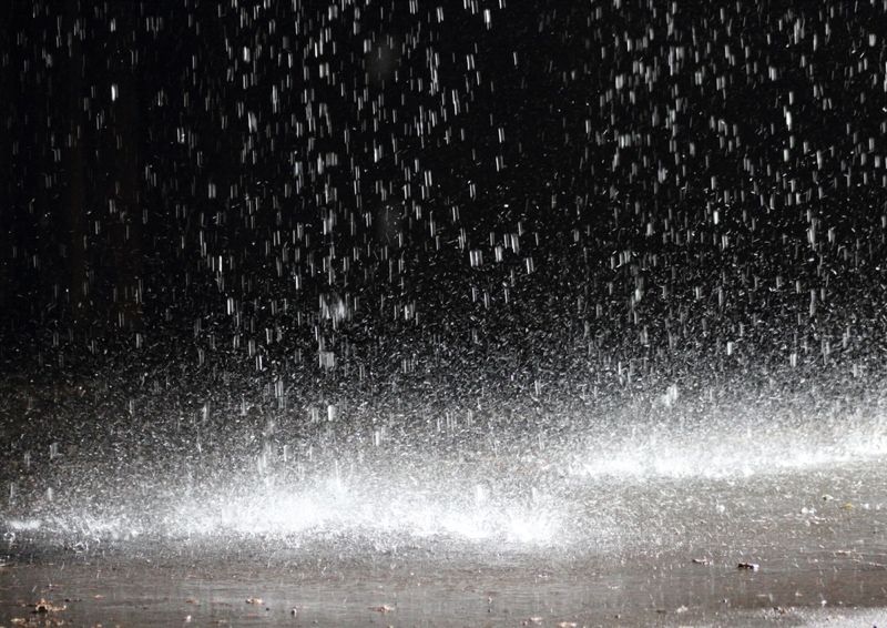 Close-up image of rainfall on asphalt.