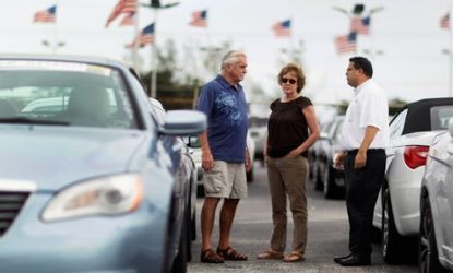 A couple considers purchasing a car at a Chrysler dealership in Florida: Increased vehicle sales were one factor that helped boost the U.S. economy grow at a 2.5 percent pace in the third qua