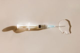 a white needle with liquid on a cream background