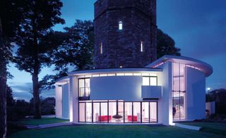 two-storey extension with glass façade wraps around this listed water tower