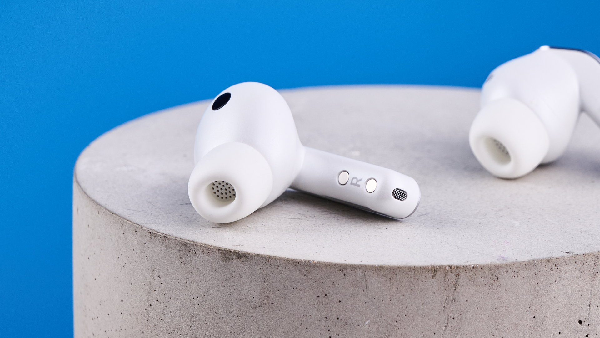 the samsung galaxy buds 4 pro in white photographed against the blue tom's guide background