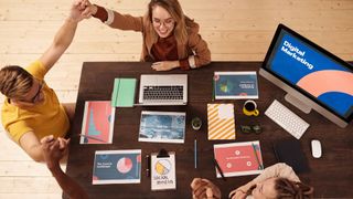 colleagues high-fiving with marketing content on table