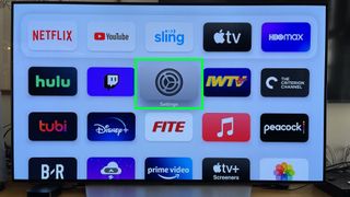 The Settings app is highlighted on the Apple TV home screen