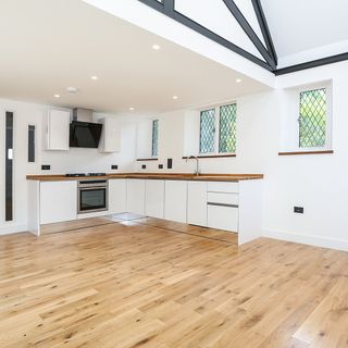 kitchen area with white kitchen cabinet and wooden flooring