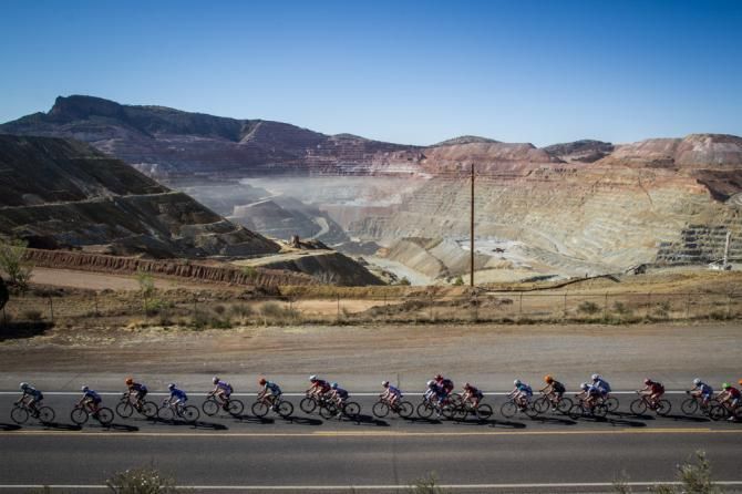 Riders pass by the massive Santa Rita mine