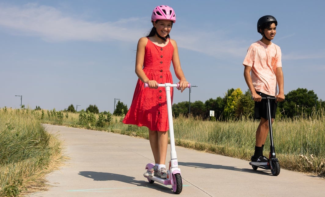 Dos niños montando scooters eléctricos GoTrax GKS plus