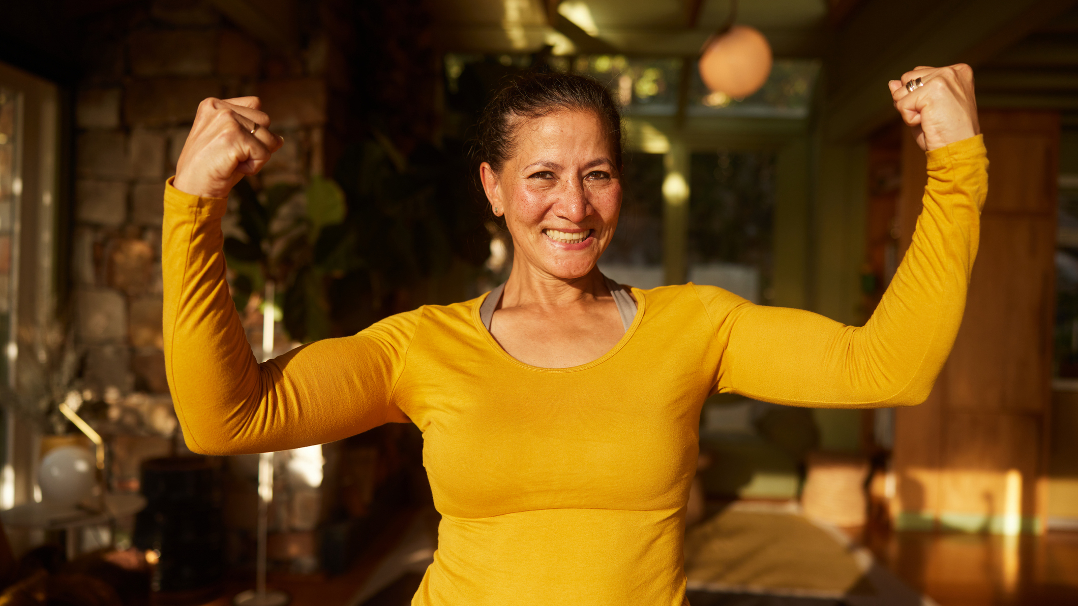 Smiling woman flexes her biceps