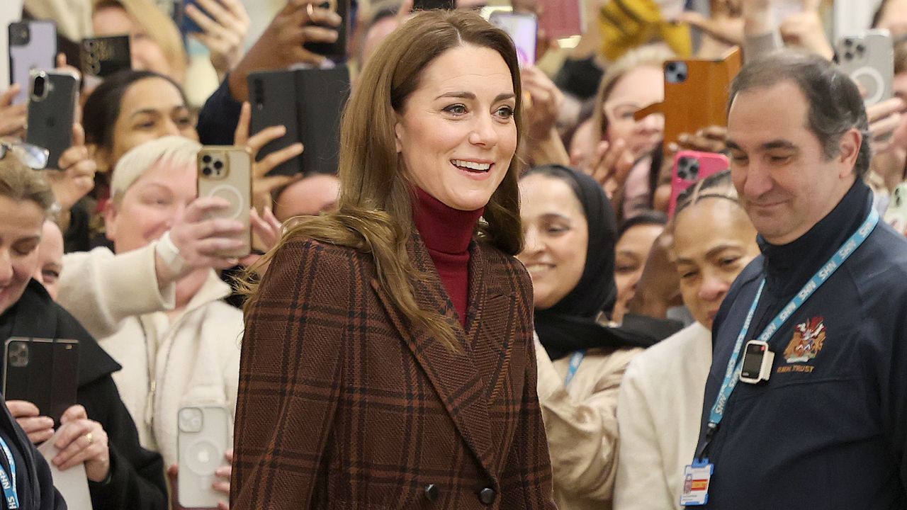 Princess Kate visits a hospital wearing a brown plaid tote and a crimson turtleneck plus an asprey bag