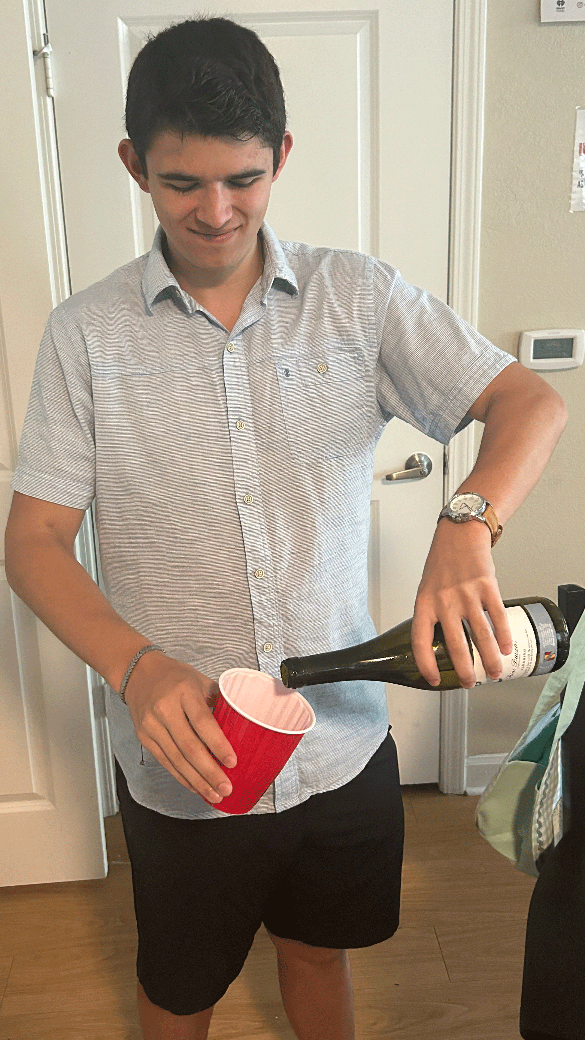 Man pouring wine into red cup