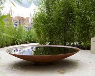 a bowl water feature in a backyard